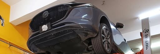 A Mazda raised on the lift at Iman Carcare