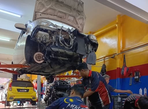 Iman Carcare mechanics working under a car on the lift