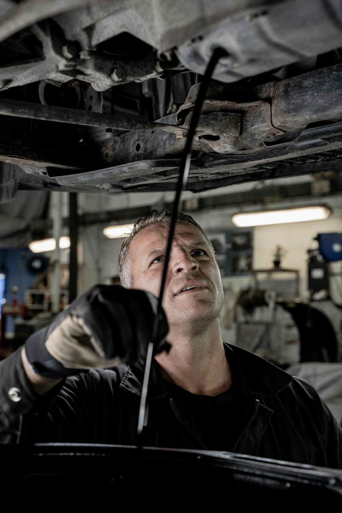 Stand-in Unsplash photo of a mechanic working under a car