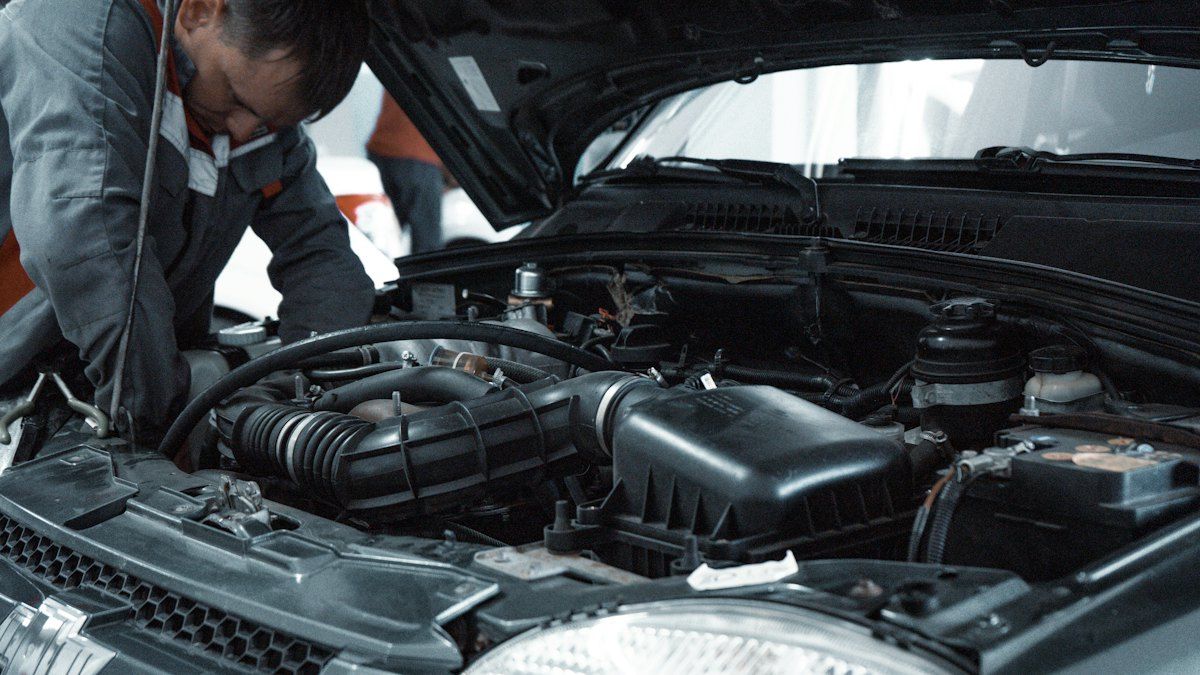 Stand-in Unsplash photo of a mechanic inspecting an engine bay